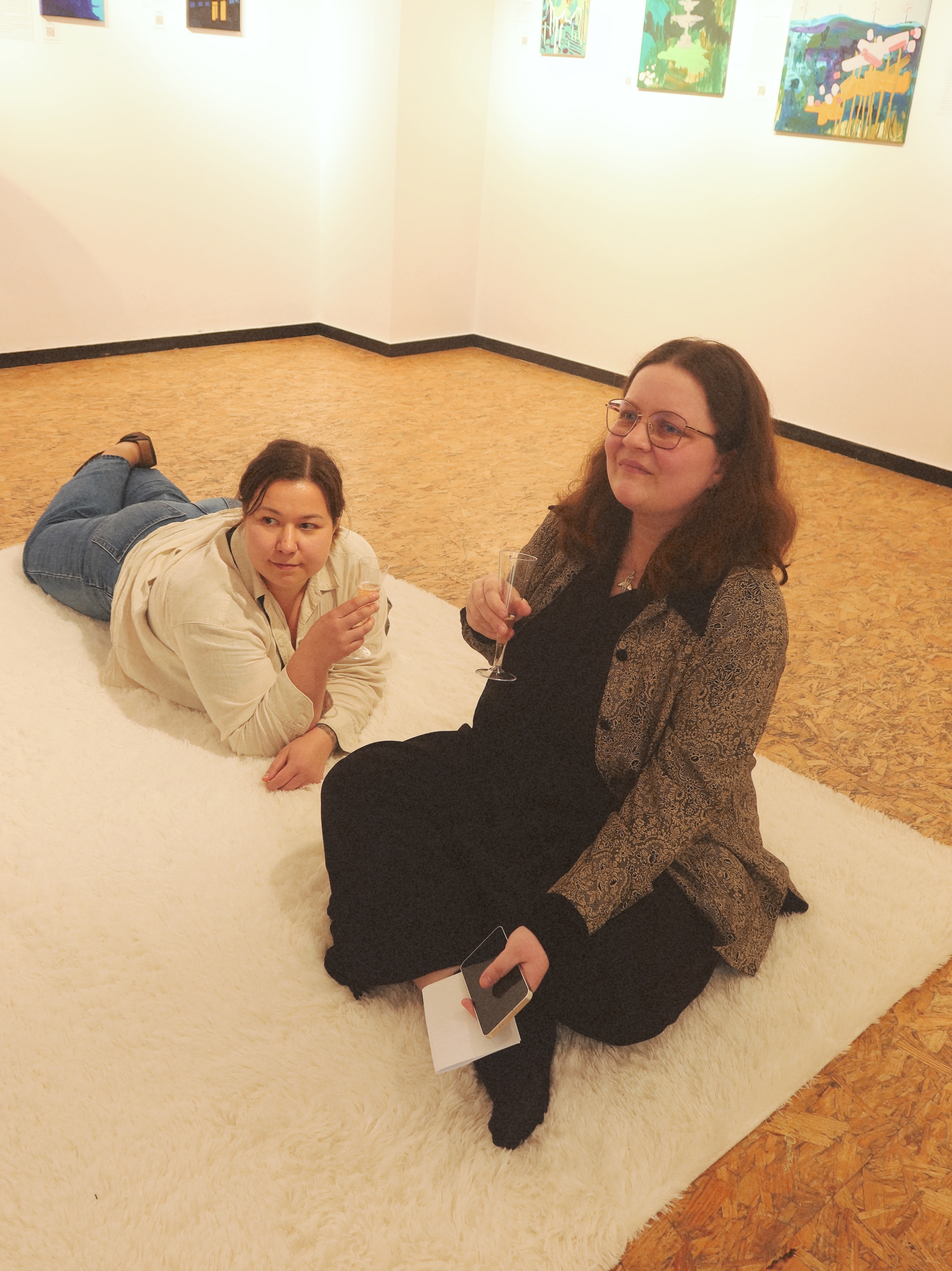Two people sitting on the white fluffy carpet