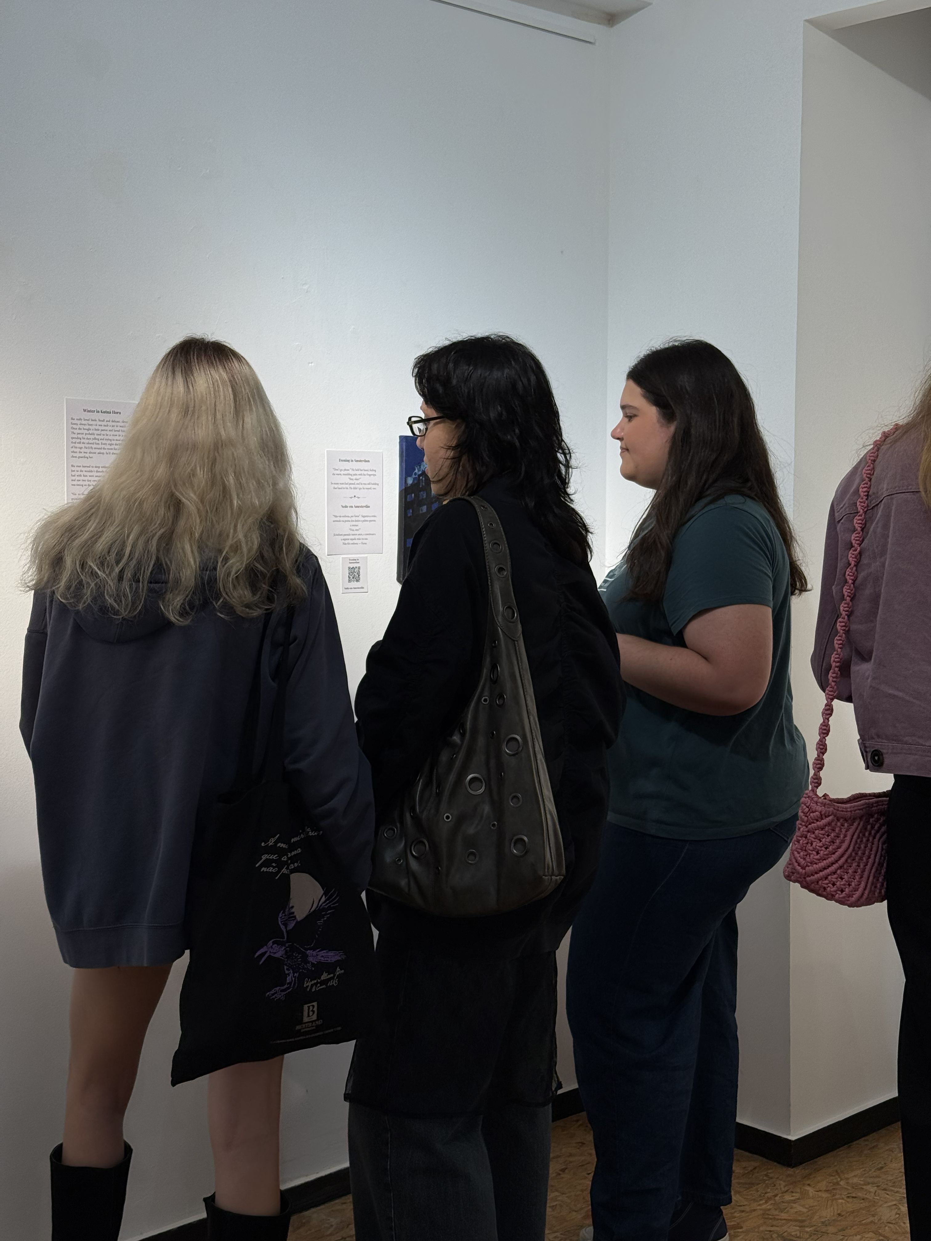 Several people in a big room with paintings
