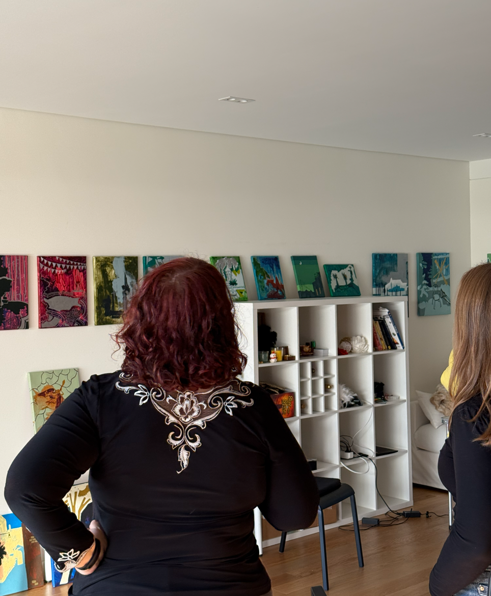 Two people discussing paintings on the walls in the well-lit room